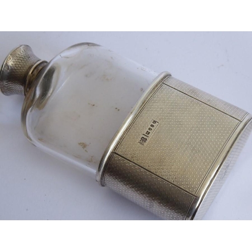 64 - A 19th century transparent glass and silver-mounted hip flask; both the engine-turned screw-top and ... 