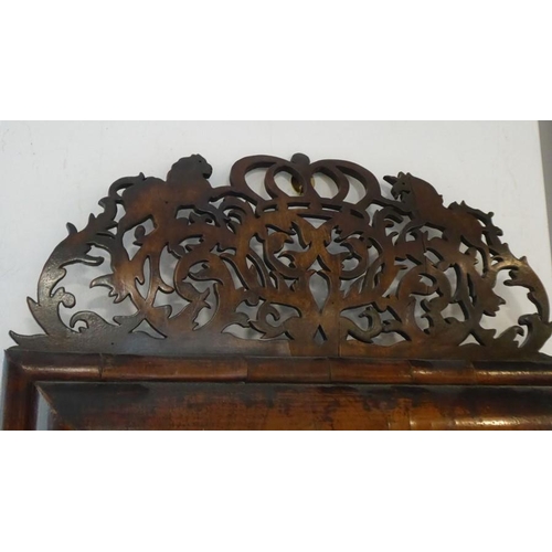 644 - A late 17th century walnut cushion-framed wall-hanging looking glass; the pierced pediment (very bow... 