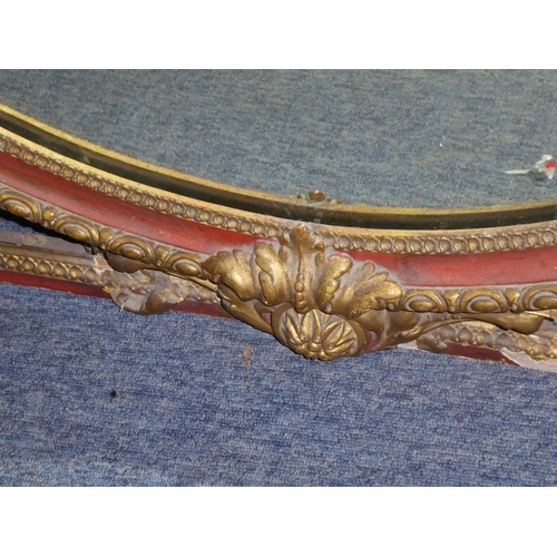 649 - A very large 19th century parcel gilt and rust-coloured painted overmantle looking glass of oval for... 