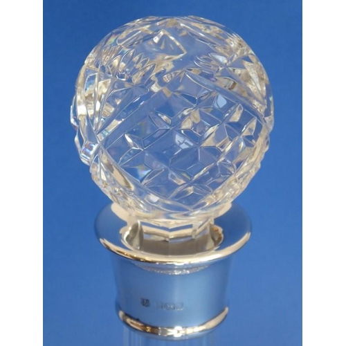 69 - A finely cut crystal ship's decanter with silver-mounted collar; the heavy spherical crystal stopper... 