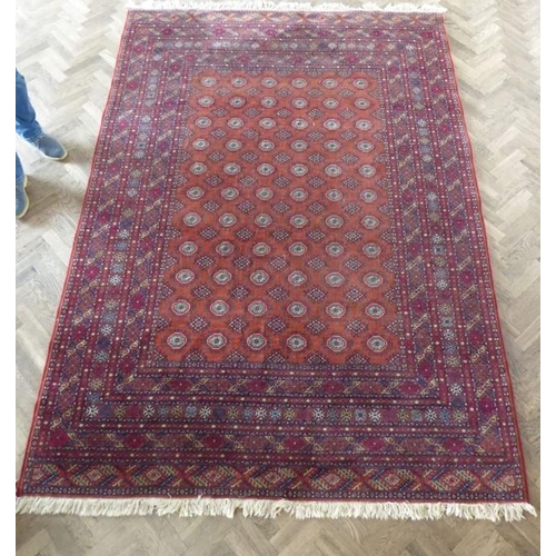 710 - A machine made orange and red ground Turkman carpet in good condition (287cm x 200cm)