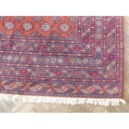 710 - A machine made orange and red ground Turkman carpet in good condition (287cm x 200cm)