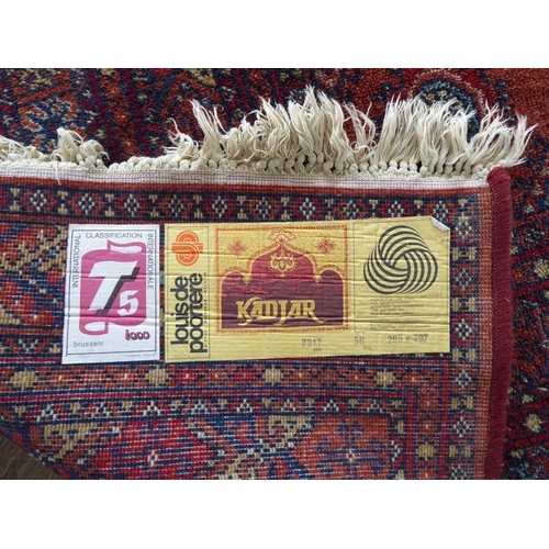 710 - A machine made orange and red ground Turkman carpet in good condition (287cm x 200cm)