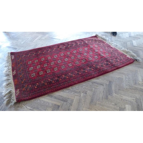 711 - A red ground Afghan carpet with gul pattern (north Afghanistan) (178cm x 106cm)