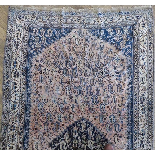 718 - A Persian Qashqai rug; central dark cobalt blue lozenge medallion full of Boteh designs against a wo... 