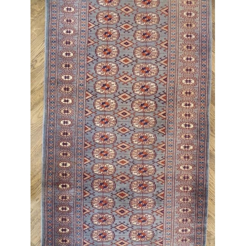 730 - A light-blue ground Pakistan runner with gul pattern (480cm x 79cm)