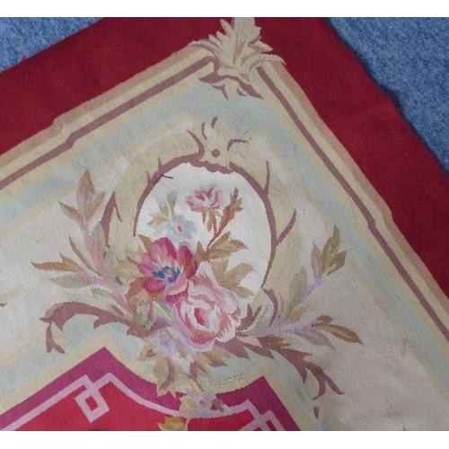 753 - An Aubusson wall-hanging tapestry with a central floral motif and crimson border decorated with vari... 