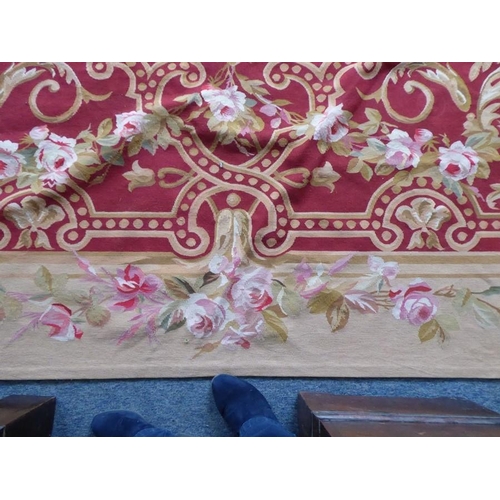 756 - An unlined Aubusson tapestry with a floral geometric pattern in red and cream/gold ornamented with p... 