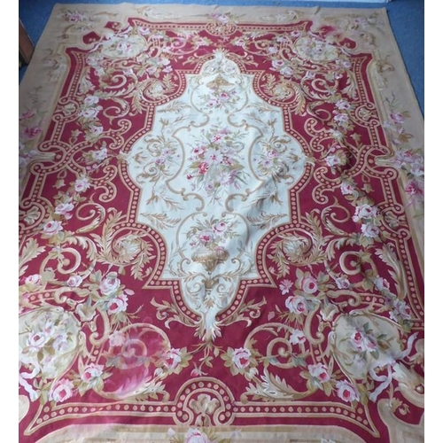 756 - An unlined Aubusson tapestry with a floral geometric pattern in red and cream/gold ornamented with p... 