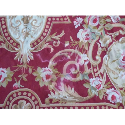 756 - An unlined Aubusson tapestry with a floral geometric pattern in red and cream/gold ornamented with p... 