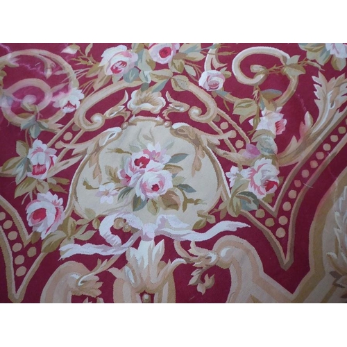 756 - An unlined Aubusson tapestry with a floral geometric pattern in red and cream/gold ornamented with p... 