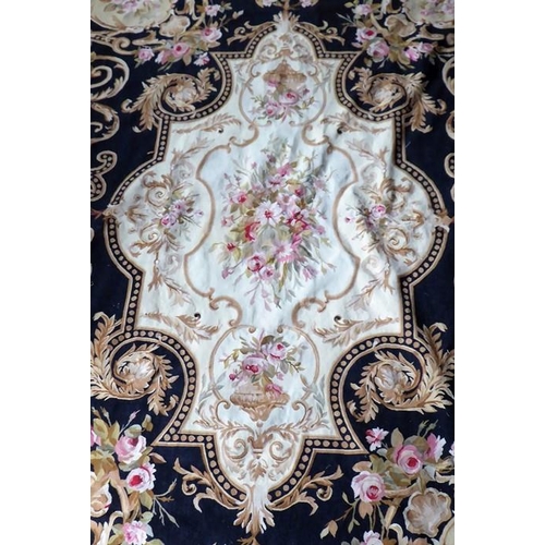 757 - An unlined Aubusson tapestry in a floral geometric pattern in black and beige with a central floral ... 