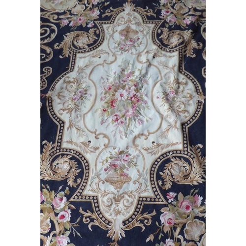 757 - An unlined Aubusson tapestry in a floral geometric pattern in black and beige with a central floral ... 