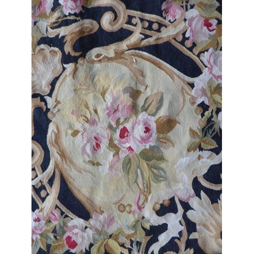 757 - An unlined Aubusson tapestry in a floral geometric pattern in black and beige with a central floral ... 