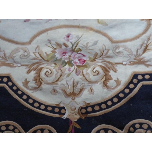 757 - An unlined Aubusson tapestry in a floral geometric pattern in black and beige with a central floral ... 