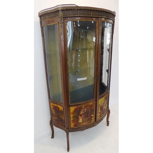 869 - A late 19th / early 20th century two-door vitrine in 18th century French style: bow-fronted, walnut ... 