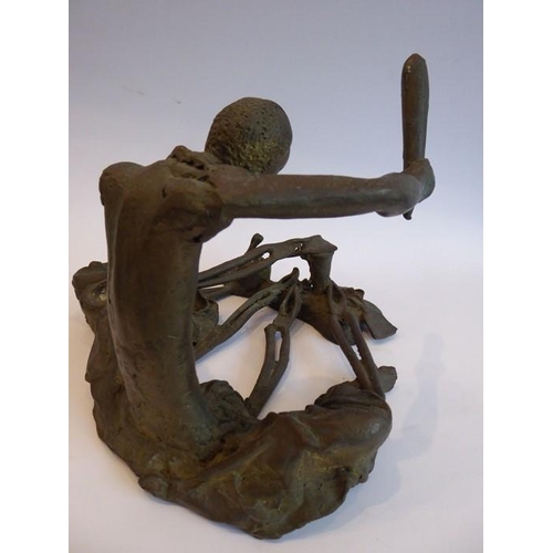 87 - A large and heavy patinated bronze sculpture of a seated African metalworker; in his left hand he ho... 