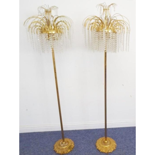 870 - A pair of mid-20th century brass floor standing lamp standards; each with curved supports and glass ... 