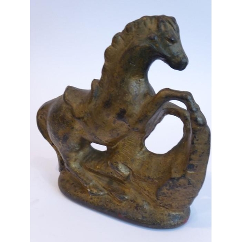 89 - A very heavy cast-iron and gold-painted door stop modelled as a rearing horse before rocks etc. (23c... 