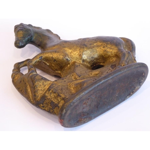 89 - A very heavy cast-iron and gold-painted door stop modelled as a rearing horse before rocks etc. (23c... 