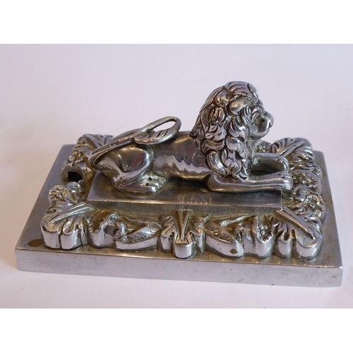 98 - A pair of heavy Art Deco period cast chrome onto brass paperweights modelled as recumbent lions on r... 