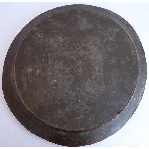 99 - A large patinated circular bronze dish/charger, 18th/19th century; with raised lip and angular sides... 