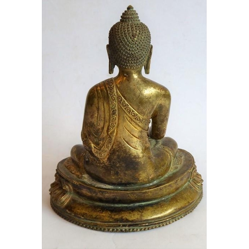 101 - A Tibetan gilt bronze medicine Buddha; the Buddha seated in dhyanasana on a double lotus throne, he ... 