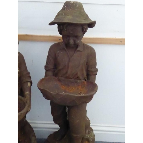 105 - A pair of weathered cast-iron bird baths; modelled as a young boy and girl standing on rockwork and ... 