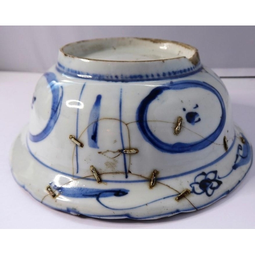 13 - A Kangxi-period Chinese porcelain bowl; hand-decorated in underglaze blue, the interior with four qu... 