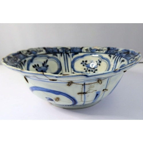 13 - A Kangxi-period Chinese porcelain bowl; hand-decorated in underglaze blue, the interior with four qu... 