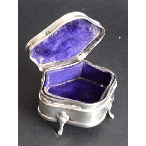 136 - A hallmarked silver jewellery/trinket box; serpentine-fronted, lined with blue velvet and raised on ... 