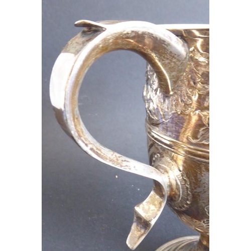 137 - An 18th century hallmarked silver two-handled trophy-style cup; later Repoussé decorated and with in... 