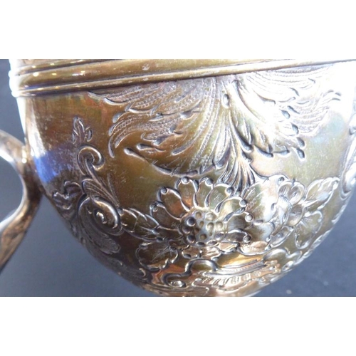 137 - An 18th century hallmarked silver two-handled trophy-style cup; later Repoussé decorated and with in... 