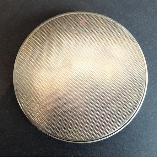 139 - An early 20th century white-metal powder compact with mirror; the hinged lid decorated in guilloche ... 