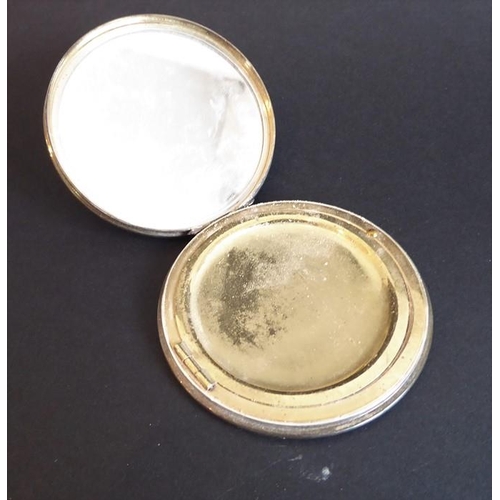 139 - An early 20th century white-metal powder compact with mirror; the hinged lid decorated in guilloche ... 