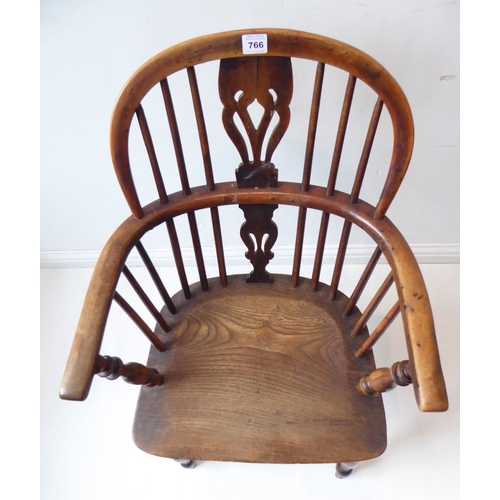 766 - A mid-19th century yew wood Windsor chair; pierced shaped splat, shaped elm seat and turned slightly... 