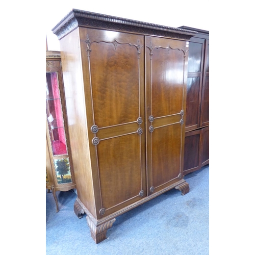 867 - An early 20th century Chippendale-style two-door mahogany wardrobe; the gadrooned and dentil cornice... 