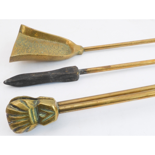 66 - An unusual set of early 20th century heavy brass fireirons: each handle modelled as a heavily cast V... 