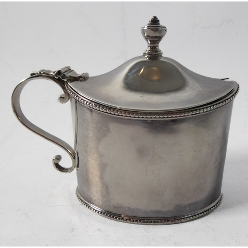 87 - A large hallmarked silver mustard of oval form and with heavy cobalt blue glass liner, maker's mark ... 