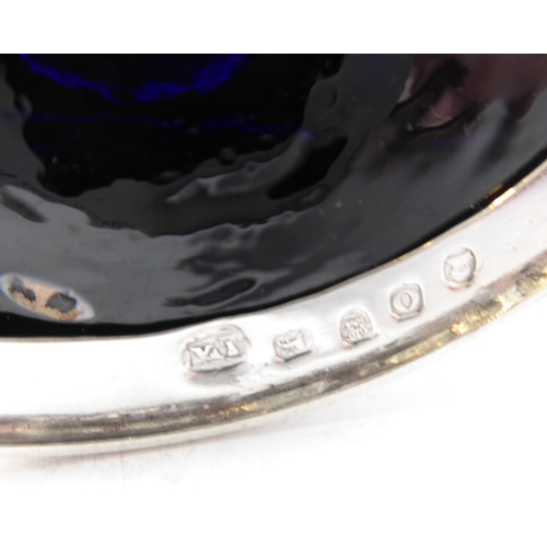 87 - A large hallmarked silver mustard of oval form and with heavy cobalt blue glass liner, maker's mark ... 