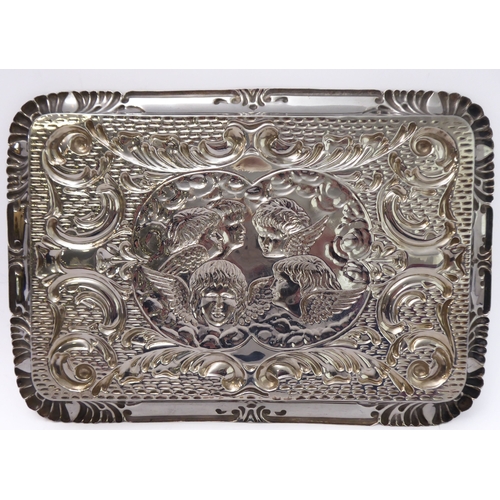 110 - A hallmarked silver trinket tray - decorated in repoussé style in relief with five winged cherubic h... 