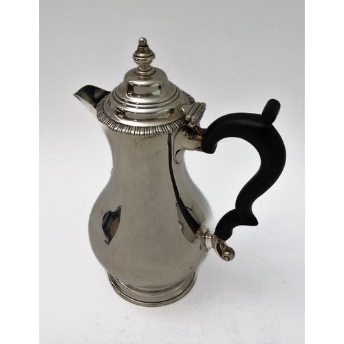 117 - A hallmarked silver hot water jug of baluster form and high arched scrolling ebonised handle, maker'... 