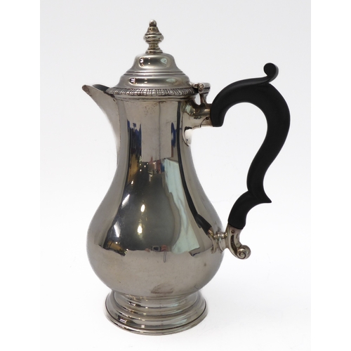 117 - A hallmarked silver hot water jug of baluster form and high arched scrolling ebonised handle, maker'... 