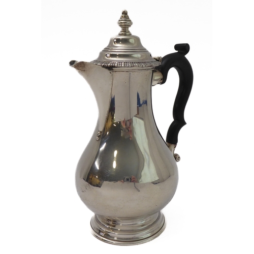117 - A hallmarked silver hot water jug of baluster form and high arched scrolling ebonised handle, maker'... 