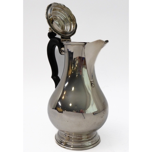 117 - A hallmarked silver hot water jug of baluster form and high arched scrolling ebonised handle, maker'... 