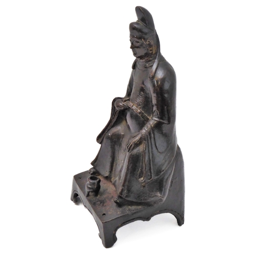 74 - A patinated Chinese bronze of a high ranking official with headdress and long flowing robe, seated b... 