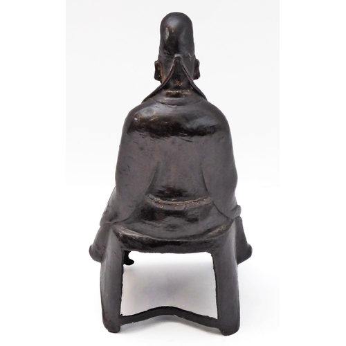 74 - A patinated Chinese bronze of a high ranking official with headdress and long flowing robe, seated b... 