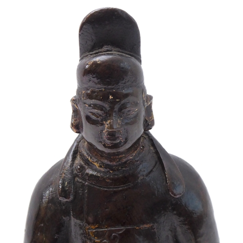 74 - A patinated Chinese bronze of a high ranking official with headdress and long flowing robe, seated b... 