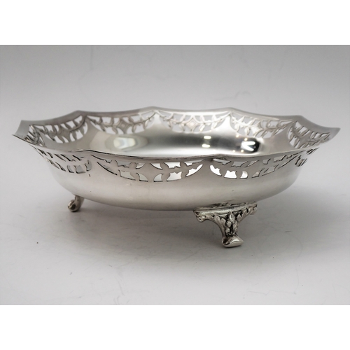 96 - A hallmarked silver bowl; pierced swag style border and raised on three foliate cast feet, maker's m... 