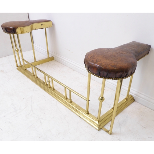 85 - A good brass and leather upholstered club fender; the spoon-shaped brown patinated leather seats emb... 